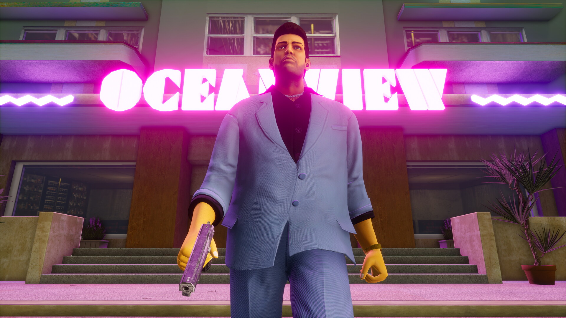 Grand Theft Auto: Vice City Definitive Edition screenshot: Tommy Vercetti outside the neon-lit Ocean View hotel
