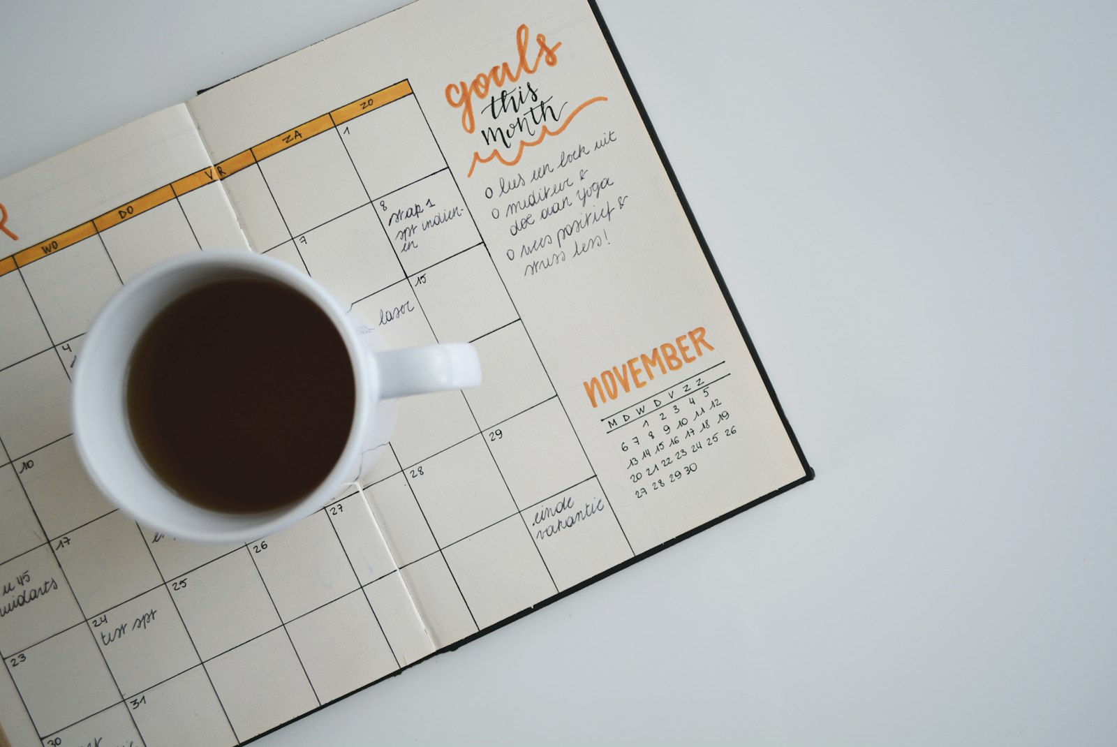 An open planner on a wooden desk