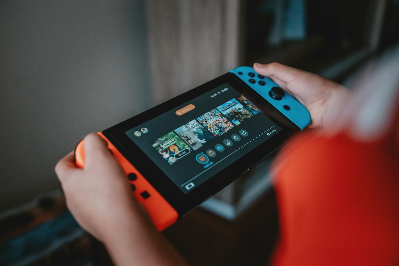 A Nintendo Switch in someone's hands: virtual game cards let a family pass games between consoles