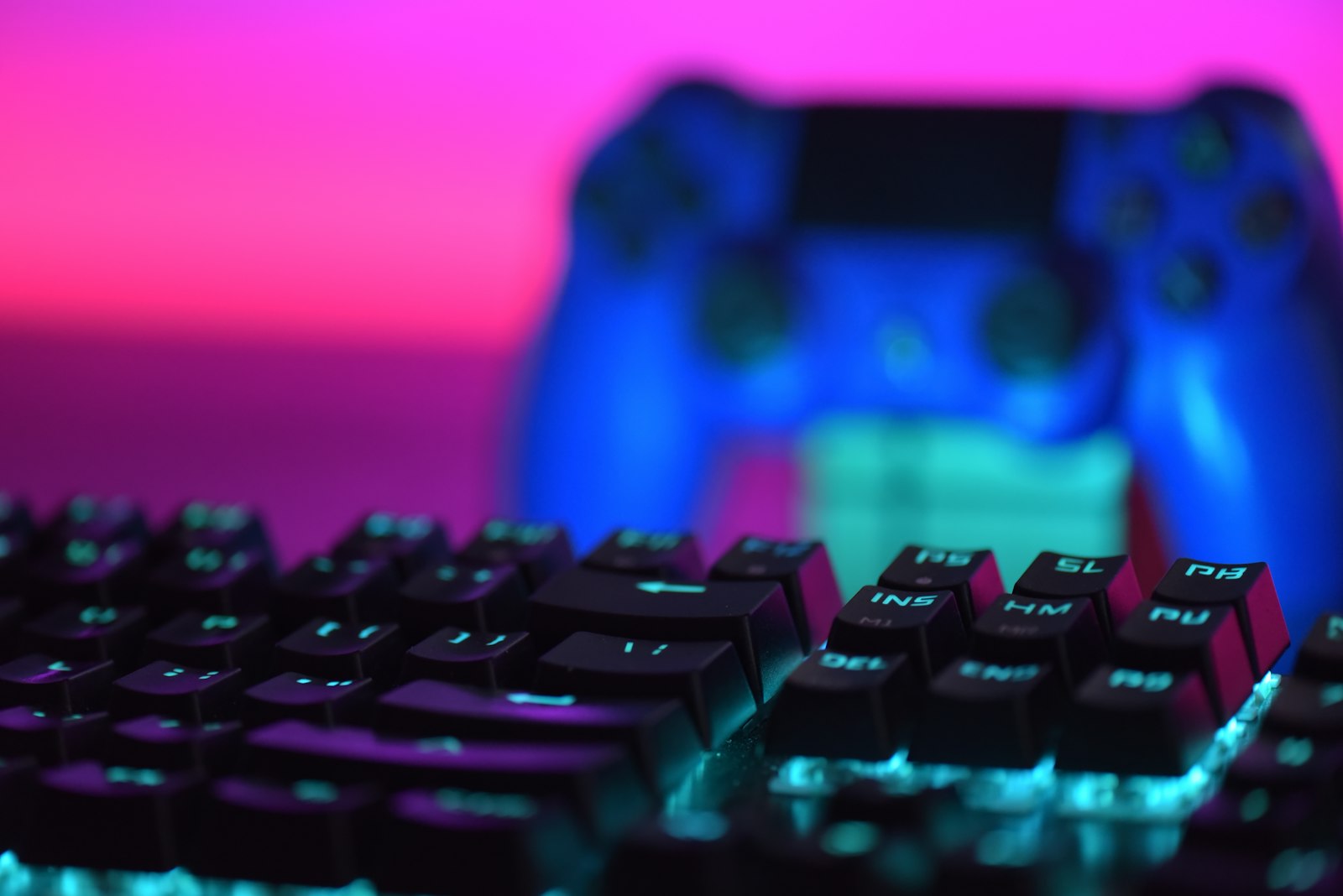 Close-up of a backlit keyboard with a game controller behind it, a typical setup for writing a video game review
